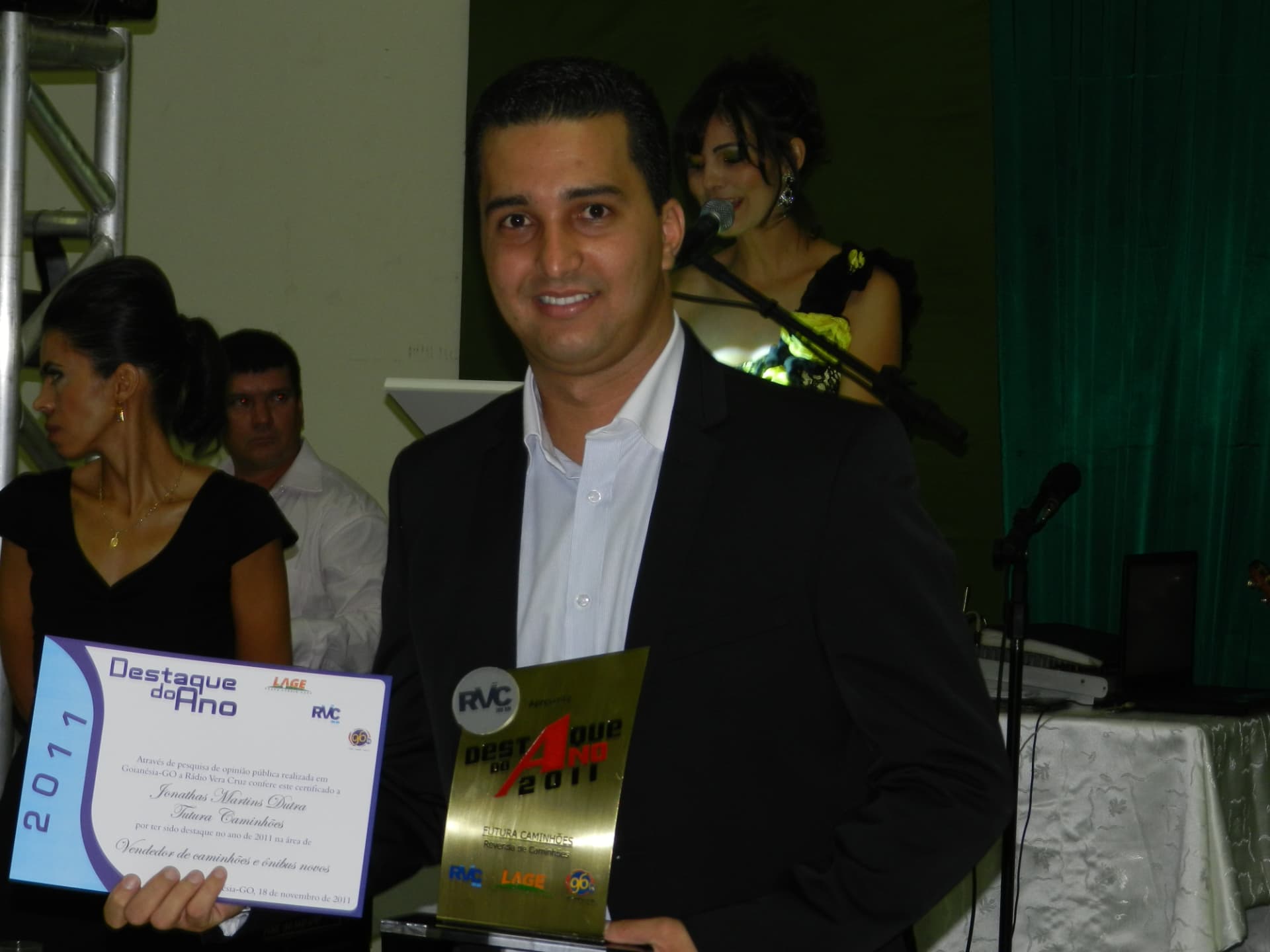 Jonathas segurando um troféu e um certificado Destaque do Ano 2011